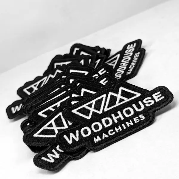 A large manufacturing run of black and white custom embroidered patches stacked in our Los Angeles factory.