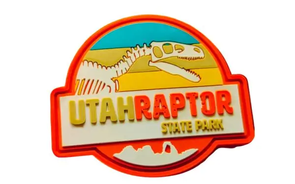 3D custom PVC patch for Utah raptor State Park featuring raised, sculpted text and a multi-layered dinosaur skeleton design.