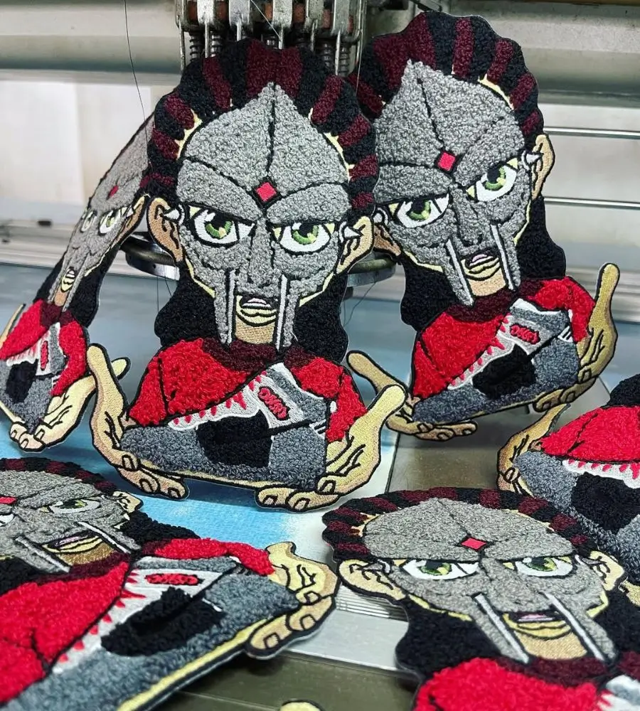 Bulk production run of custom character chenille patches on an industrial embroidery machine in Los Angeles.