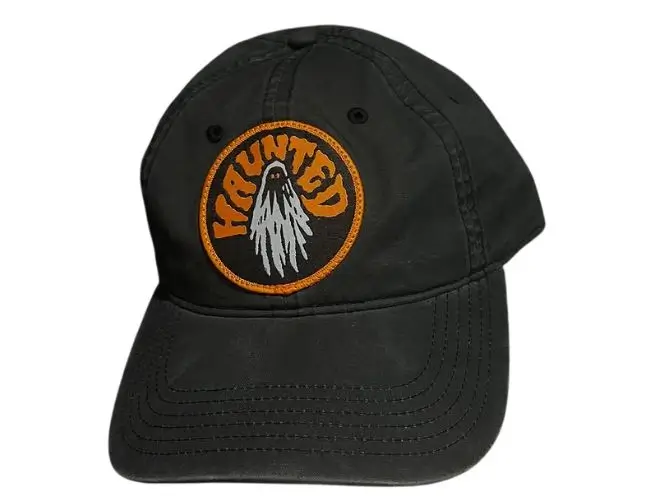 Unstructured black cotton dad hat featuring a custom circular embroidered haunted ghost patch.