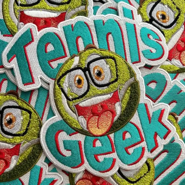 Pile of vibrant green and teal custom chenille patches for a sports organization.