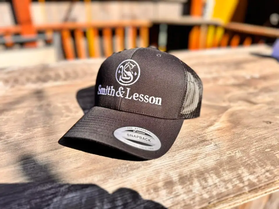 High-quality custom embroidered logo sewn onto a black premium Yupoong snapback hat.