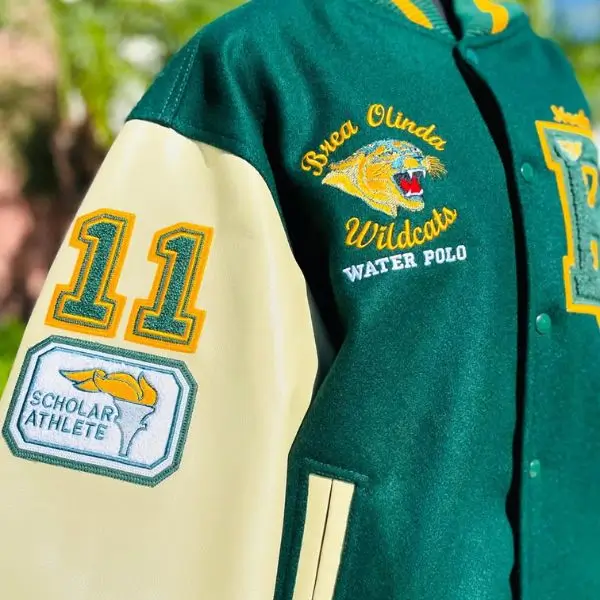 Green and cream letterman jacket featuring Brea Olinda Wildcats Water Polo embroidery and custom sleeve patches.