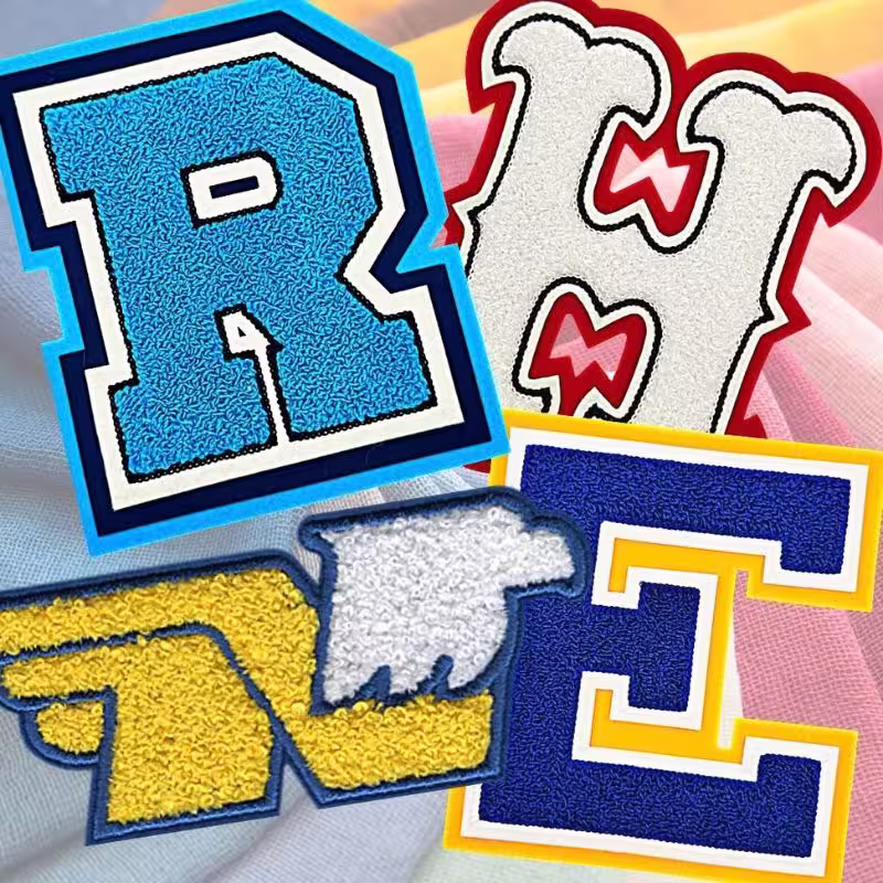 Custom fuzzy varsity letterman patches in various high school athletic colors with double-felt backing.
